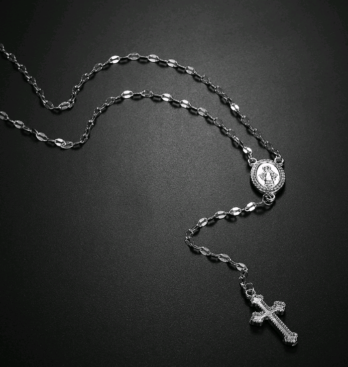 Silver necklace with a cross pendant on a black background